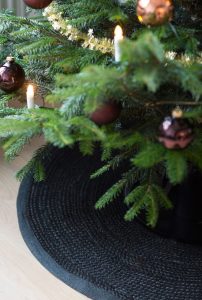 dekorerad julgran med belysning, julgransmatta i svart